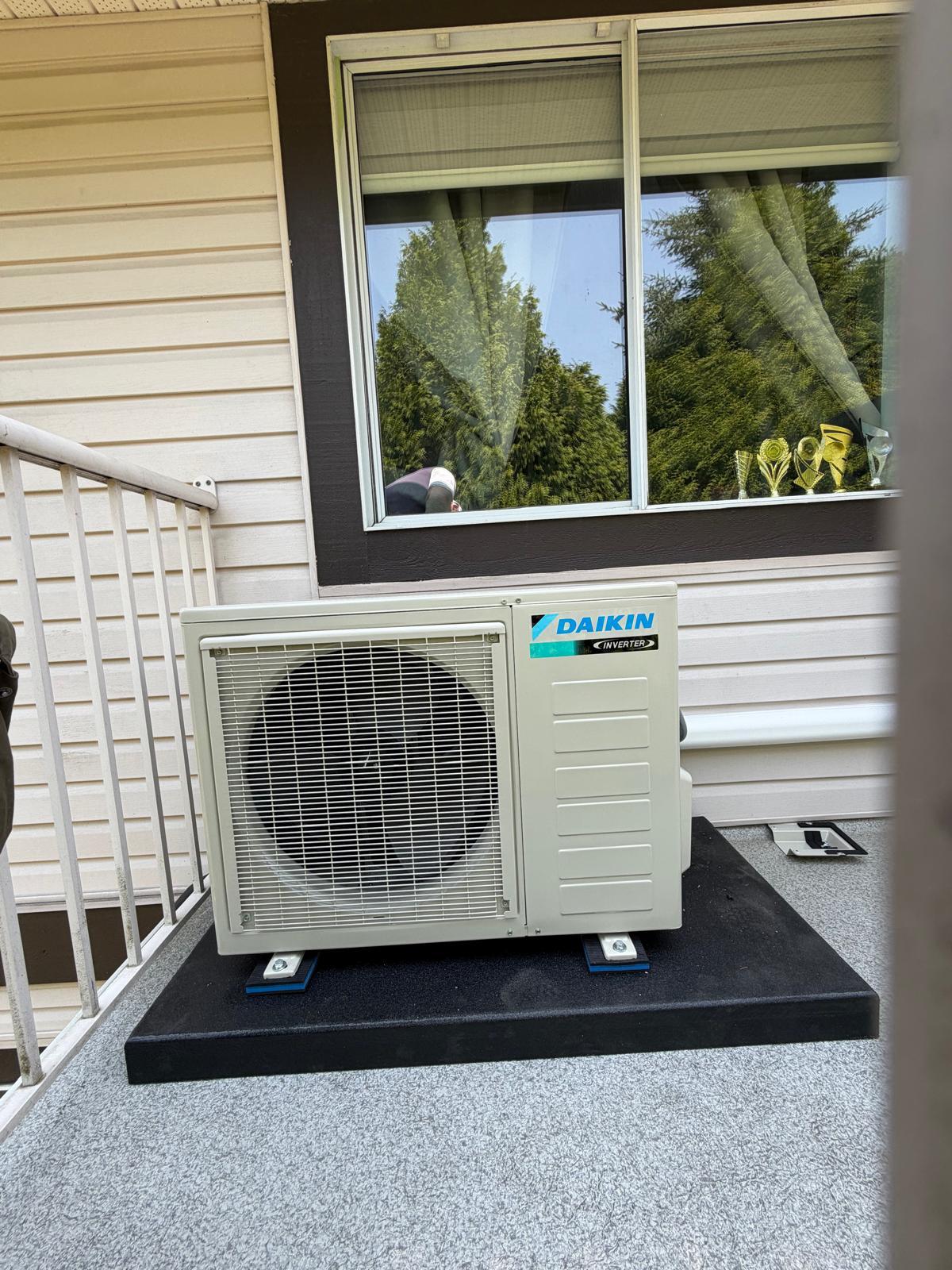 Daikin inverter heat pump outdoor unit installed beside a residential home